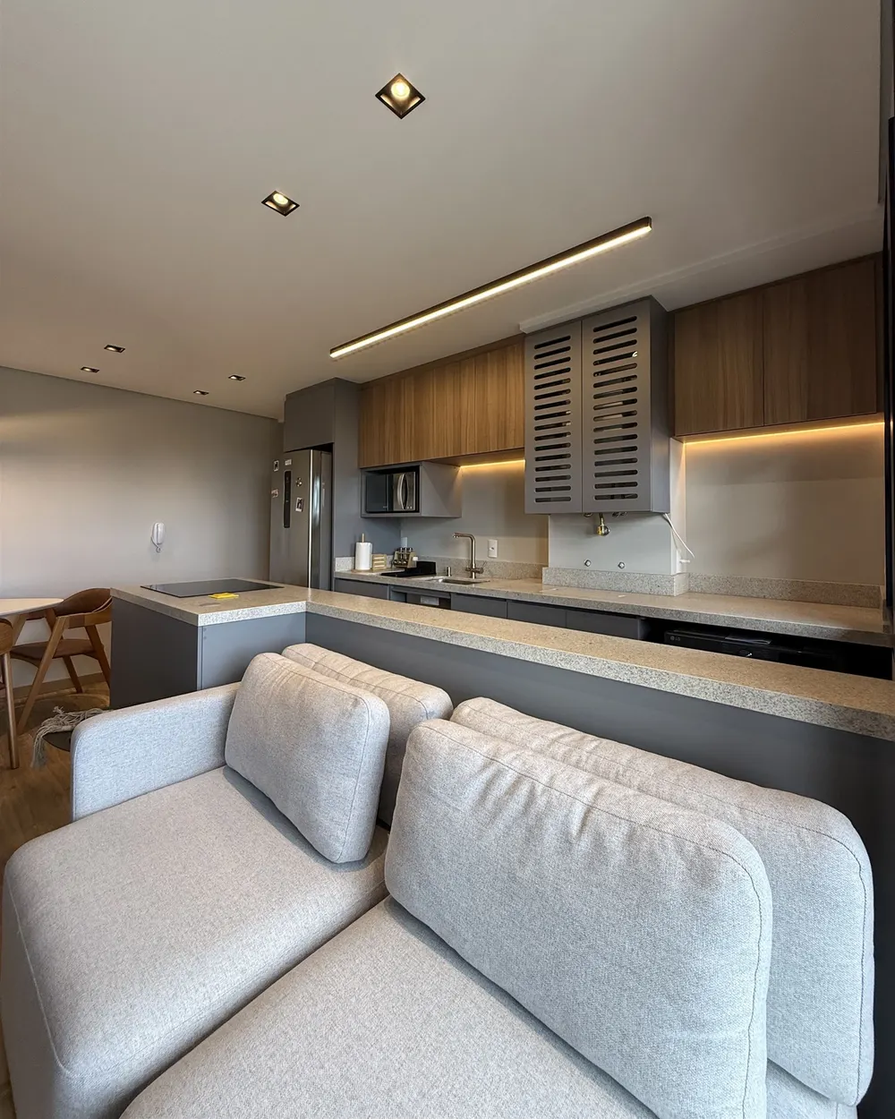 Sala e cozinha integradas do Apartamento N+R, em tons neutros