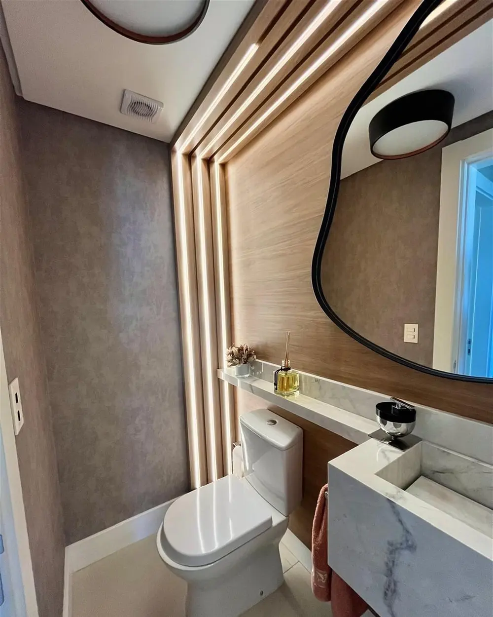 Lavabo com painel ripado e espelho orgânico