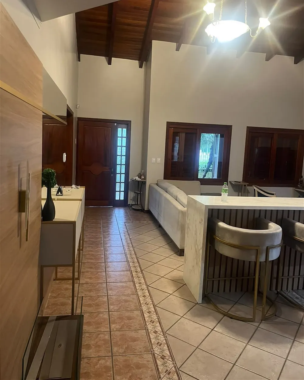 Sala do sobrado reconstruída, com bar em madeira e banquetas