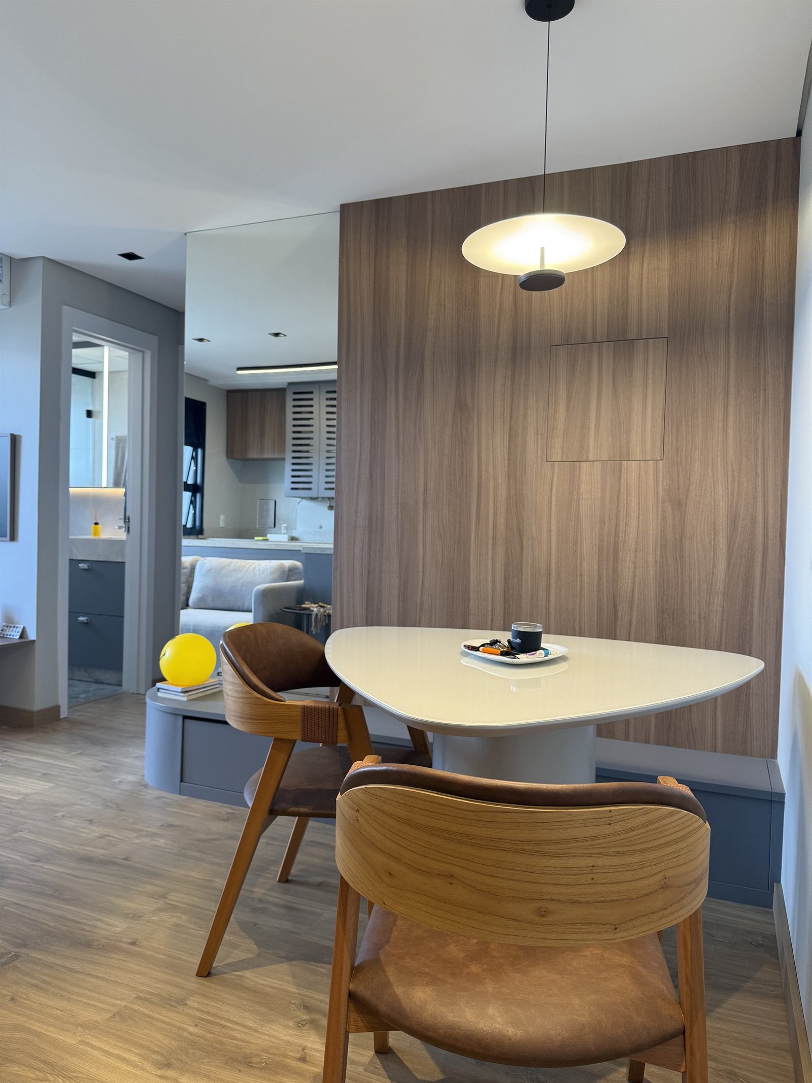 Cantinho de jantar com mesa orgânica e painel ripado em madeira