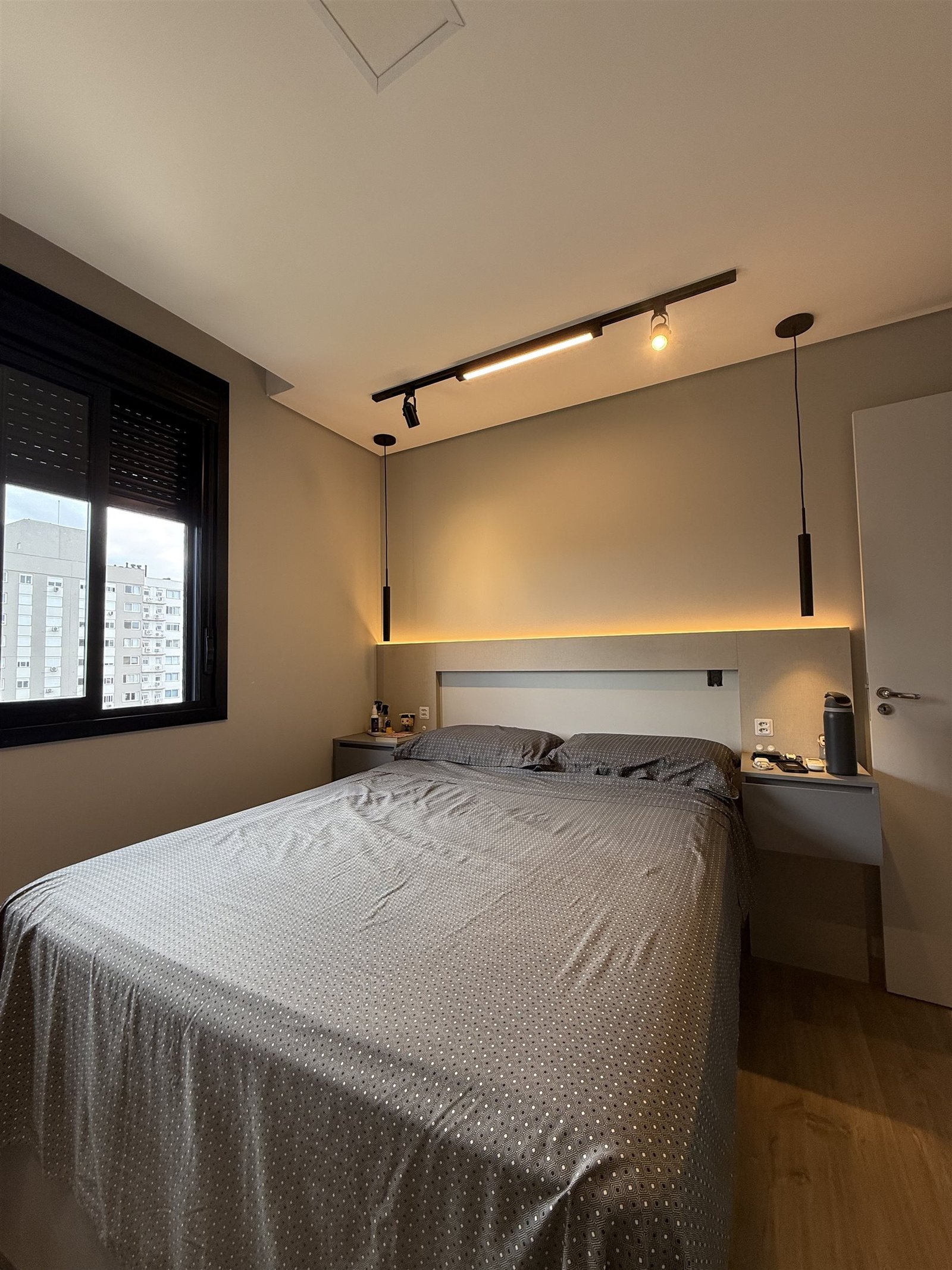 Outro ângulo do quarto do casal, com a cama e a janela ao fundo