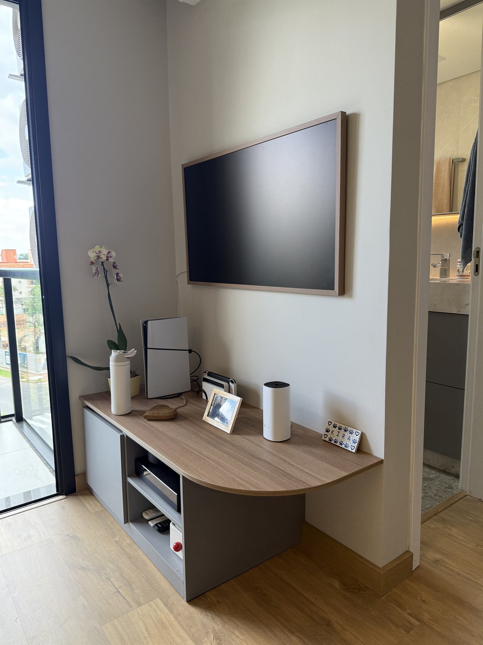 Painel de TV com moldura em madeira e credenza baixa