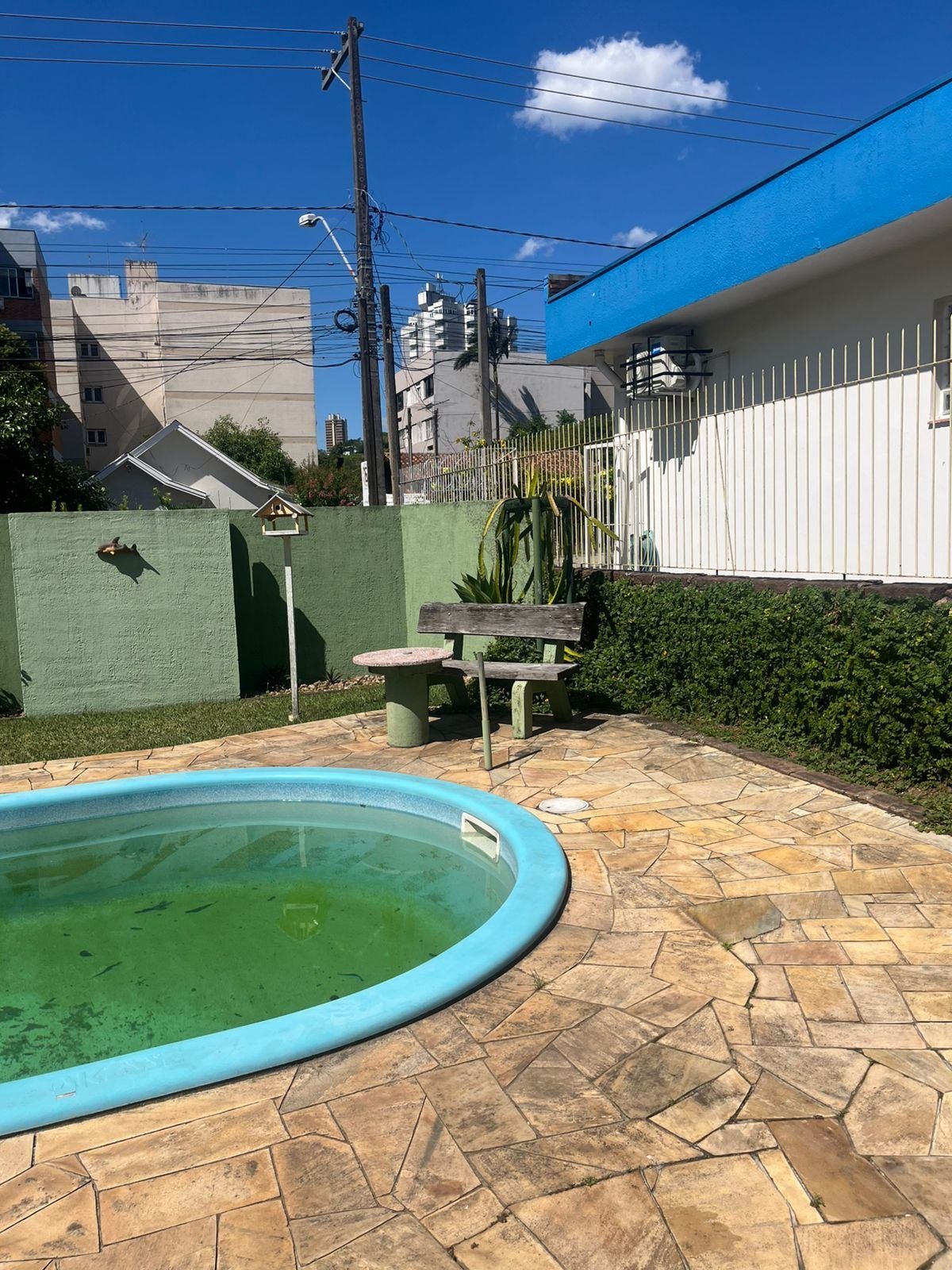 Quintal antigo da casa, com piscina de plástico desativada e sem uso