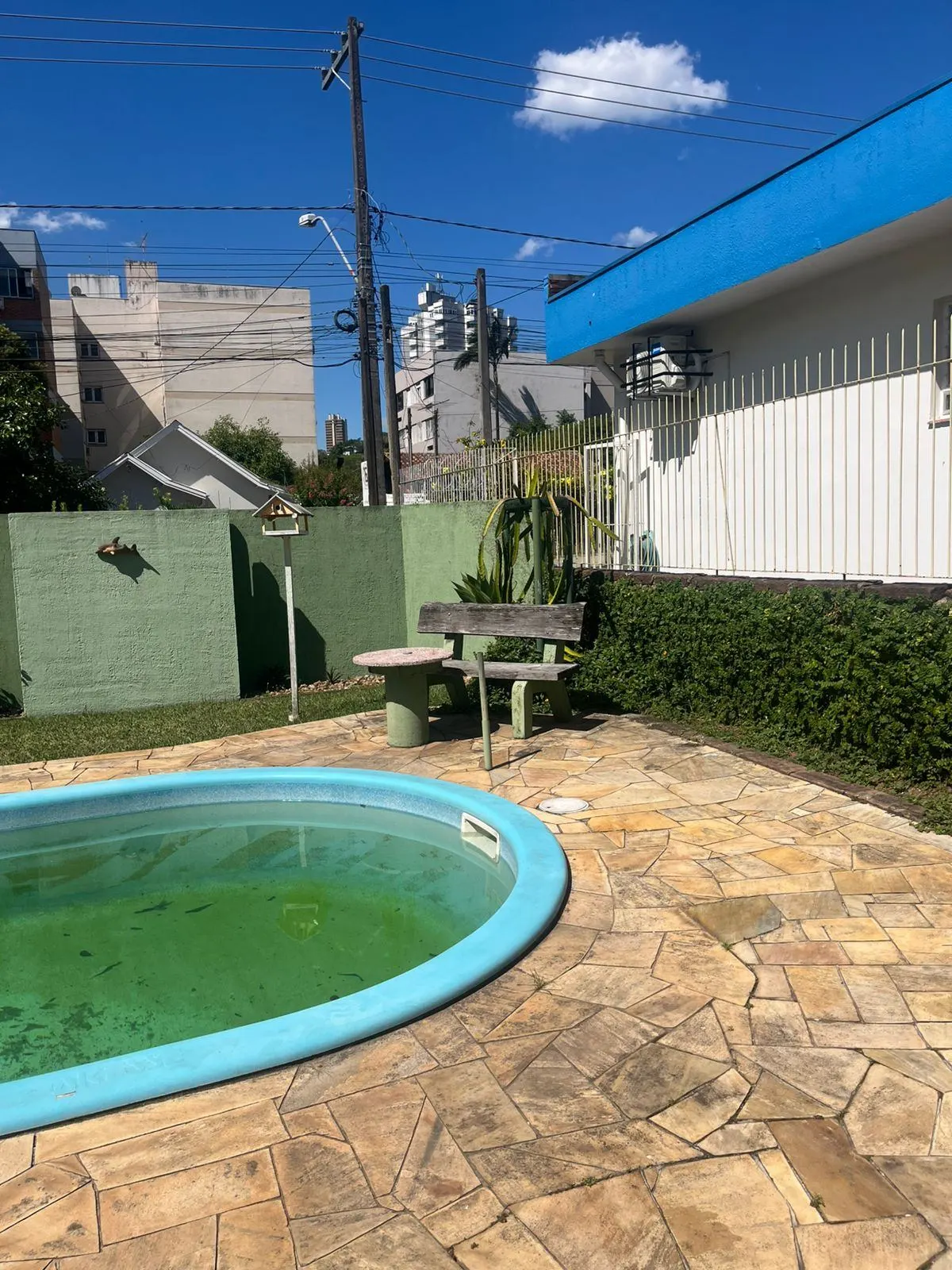 Quintal antigo da casa, com piscina de plástico desativada e sem uso