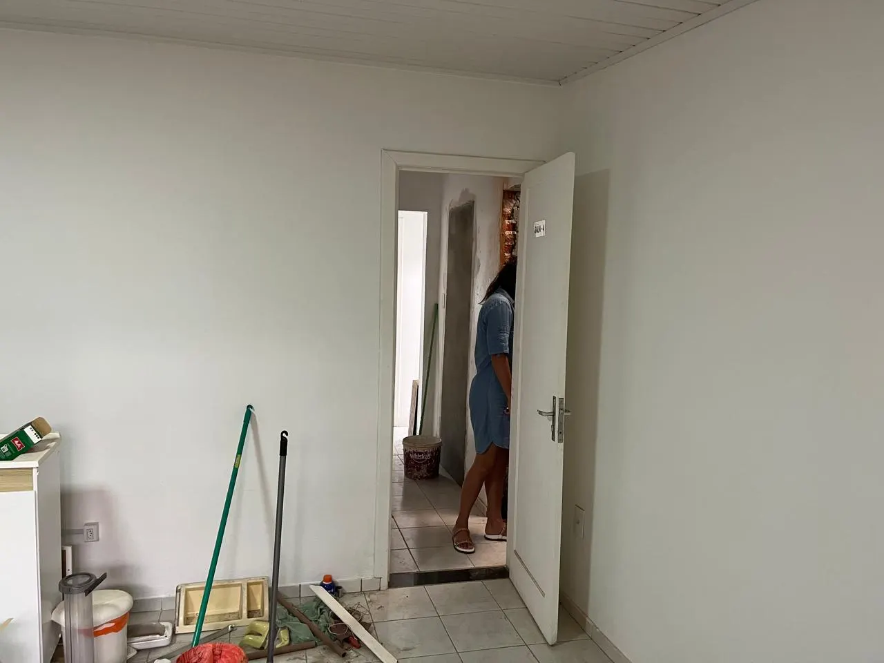 Sala vazia antes da reforma, piso antigo e parede sem acabamento