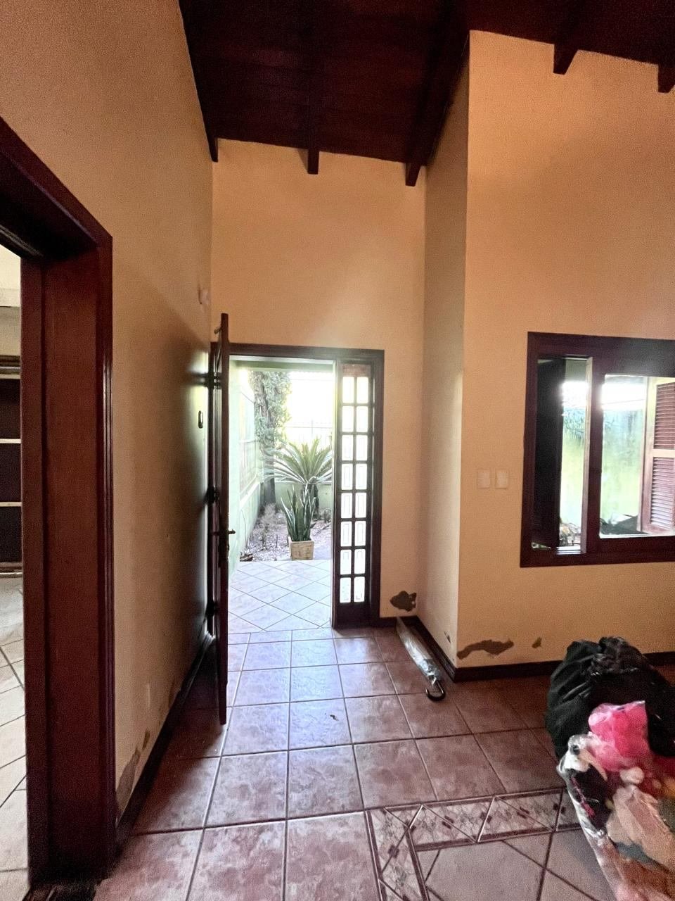 Corredor de entrada antes da reforma, vazio, apenas com a porta de madeira