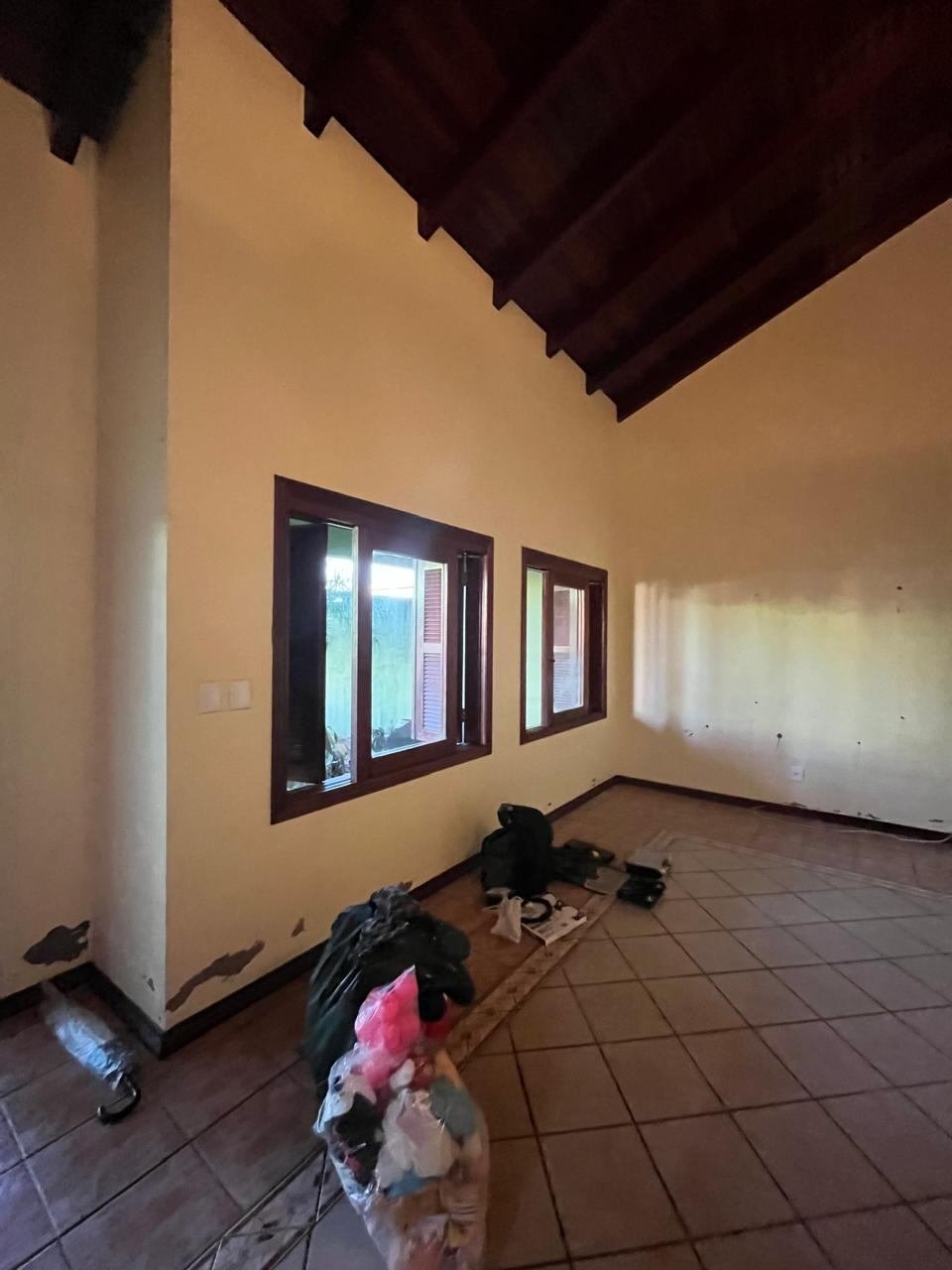 Sala antes da reforma, danificada pela enchente, com pintura descascada