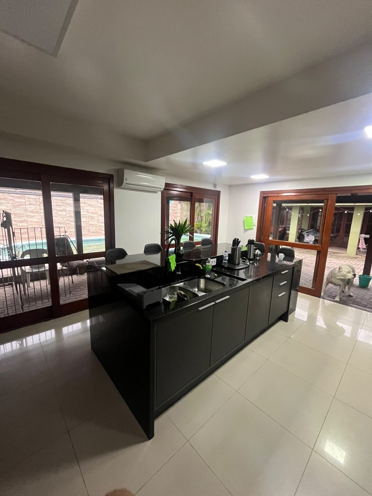 Mesma cozinha reconstruída, com ilha ampla e marcenaria em grafite