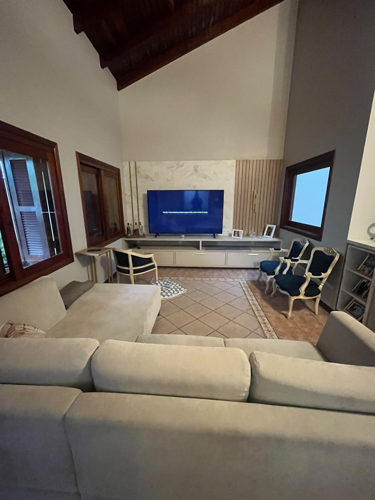 Mesma sala reconstruída, com sofá, poltronas e painel de TV novo