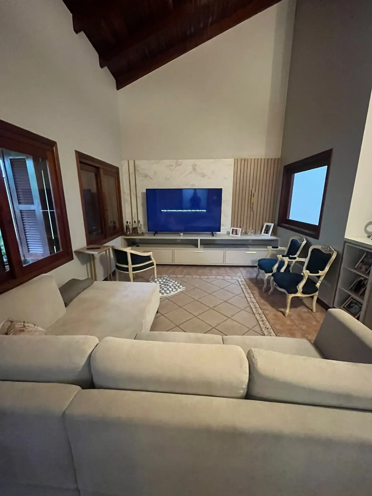 Mesma sala reconstruída, com sofá, poltronas e painel de TV novo